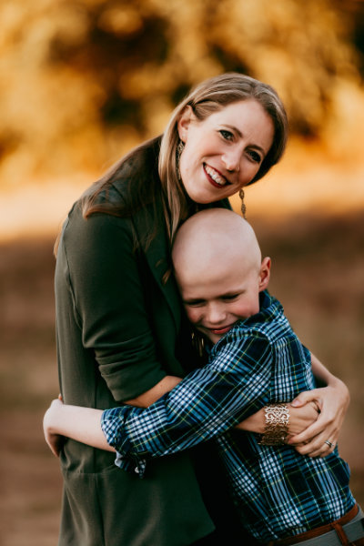 Dr. Courtney Horvath and her son Colby (still bald from his cancer treatments) hugging and smiling