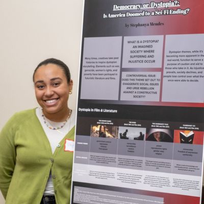 Stephanya Mendes '25, education major, presenting her poster on Democracy or Dystopia?