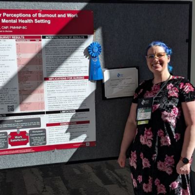 Amanda Richardson poses next to her poster at the American Psychiatric Nurses Association Conference